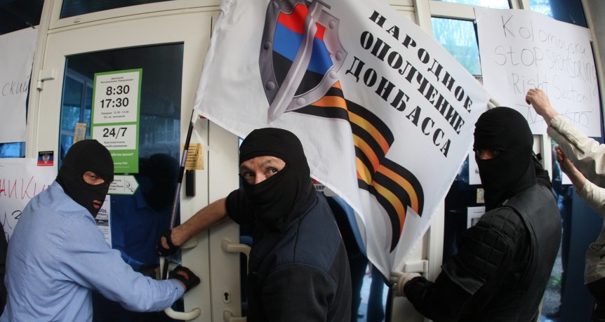 Pro-Russian militiants attack a branch of Ukrainian bank Privatbank in the eastern Ukrainian city of Donetsk on April 28, 2014. Some 300 masked pro-Russian militants wielding baseball bats attacked a branch of the bank owned by an oligarch regional governor who has voiced criticism of Moscow. The gang attacked the Donetsk office of the powerful Private banking and metal industry holding belonging to Igor Kolomoisky, a billionaire who is also governor of the nearby region of Dnipropetrovsk. AFP PHOTO/ ALEXANDER KHUDOTEPLY (Photo credit should read Alexander KHUDOTEPLY/AFP/Getty Images)